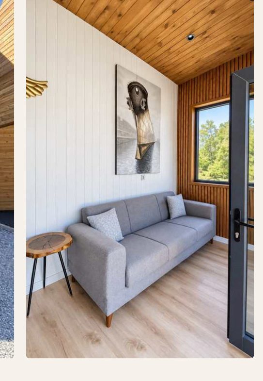 Linea – Wohnbereich mit Sofa und Holzdecke